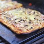 Varm pizza bagt på en bagesten i en kuglegrill