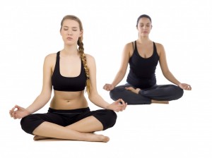 Kvinder mediterer i yoga positurer