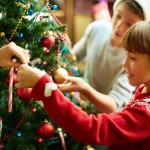 Lille pige hjælper med at pyntejuletræet - jul