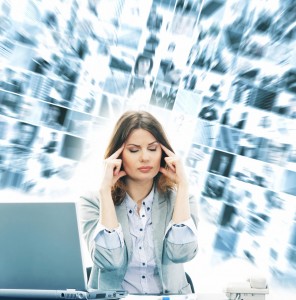 Stress - kvinde foran computer har tusinde tanker i hovedet