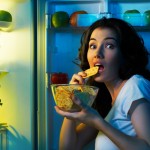 Kvinde bliver overrasket mens hun snacker fra køleskabet